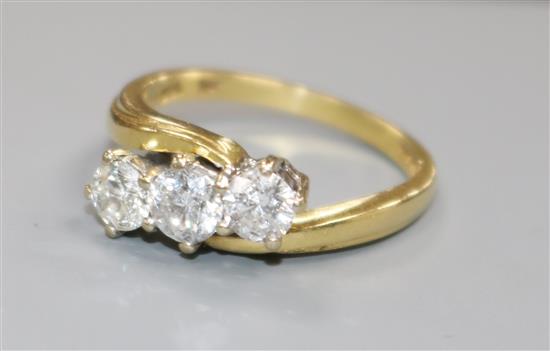 An 18ct gold and three stone diamond crossover ring, size N/O.